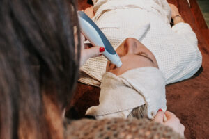 Image of a female employee performing a facial procedure, whether it's hydration, rejuvenation, or deep cleansing.